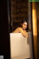 A woman sitting in a bathtub in a bathroom.