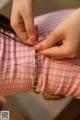 A woman is putting a chain around her wrist.