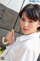 A woman in a white shirt holding an umbrella.