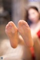 A close up of a person's bare feet in front of a window.