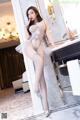 a woman in a white lingerie posing in front of a mirror